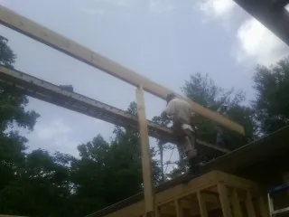 Carpenter setting a ridge beam over a new addition frame — Ice Dam Removal by Roofing Brothers in Howard Beach