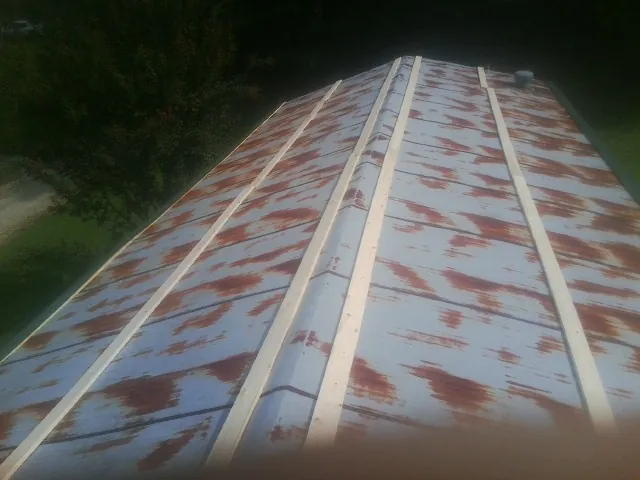Rusted metal roof panels with new wood purlins before replacement — Storm Damage Roof Repair in Howard Beach by Roofing Brothers