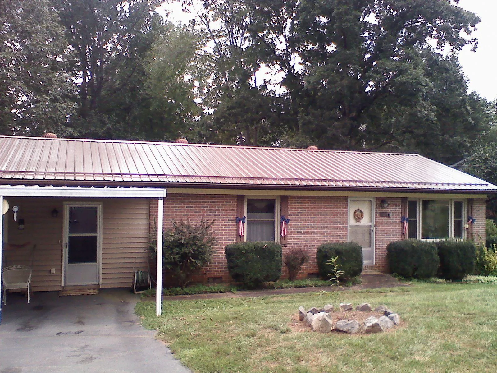 Bronze metal roof and carport on a brick ranch home — Roof Repair work by our crew in Howard Beach