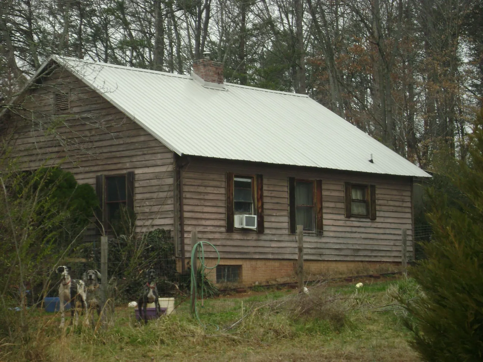 White metal roof on an old wood sided farmhouse, from a Metal Roof Installation job in Howard Beach